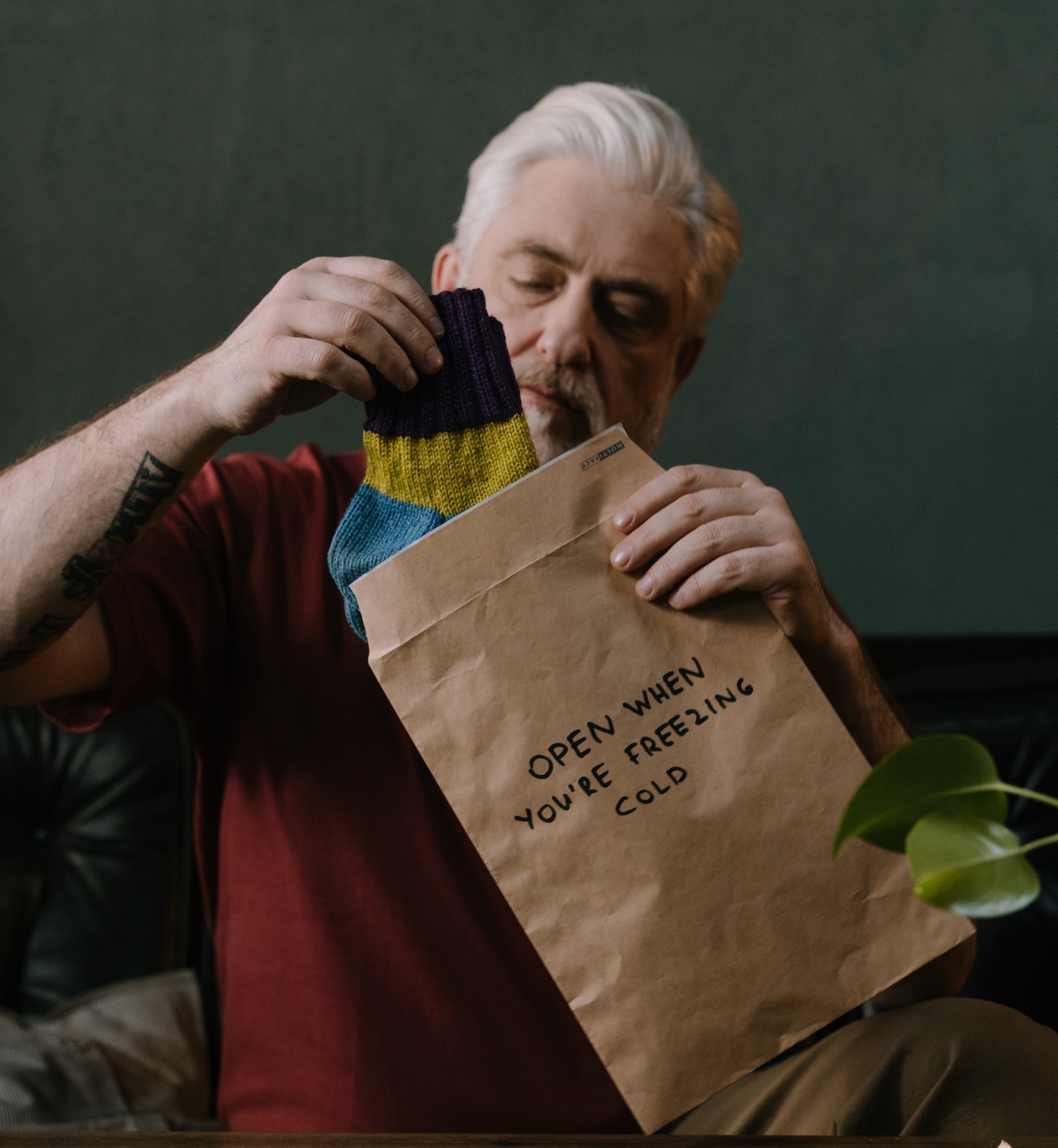 uomo cinquantenne apre un pacco di un regalo pensato ed è felice